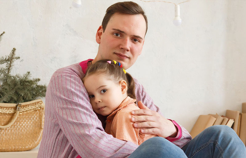 Photo of a father holding his daughter